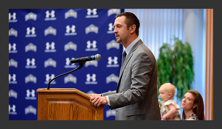 dan engelstad talks at the podium during his introductory press conference