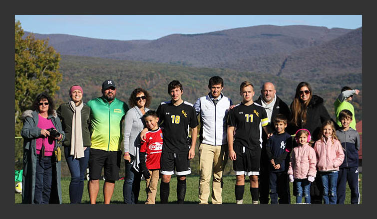 men's soccer seniors and their friends & family pose for a photo with coach gilmore