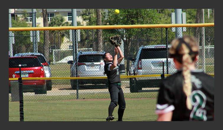 taylor jarosz catches a ball up against the fence