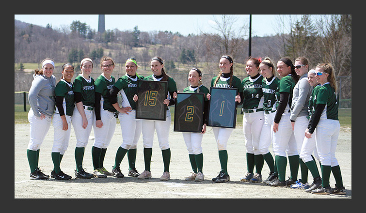 the softball team poses with the three seniors in the center